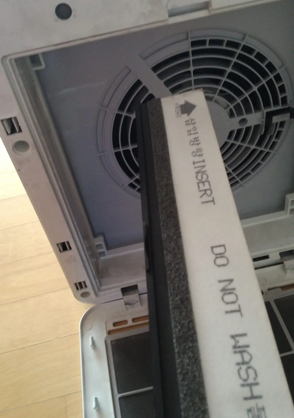 헌 필터 옆면. 삽입방향 INSERT 화살표와 DO NOT WASH 물세척 금지 표기, 검은 숯층과 흰 헤파층이 겹친 단면