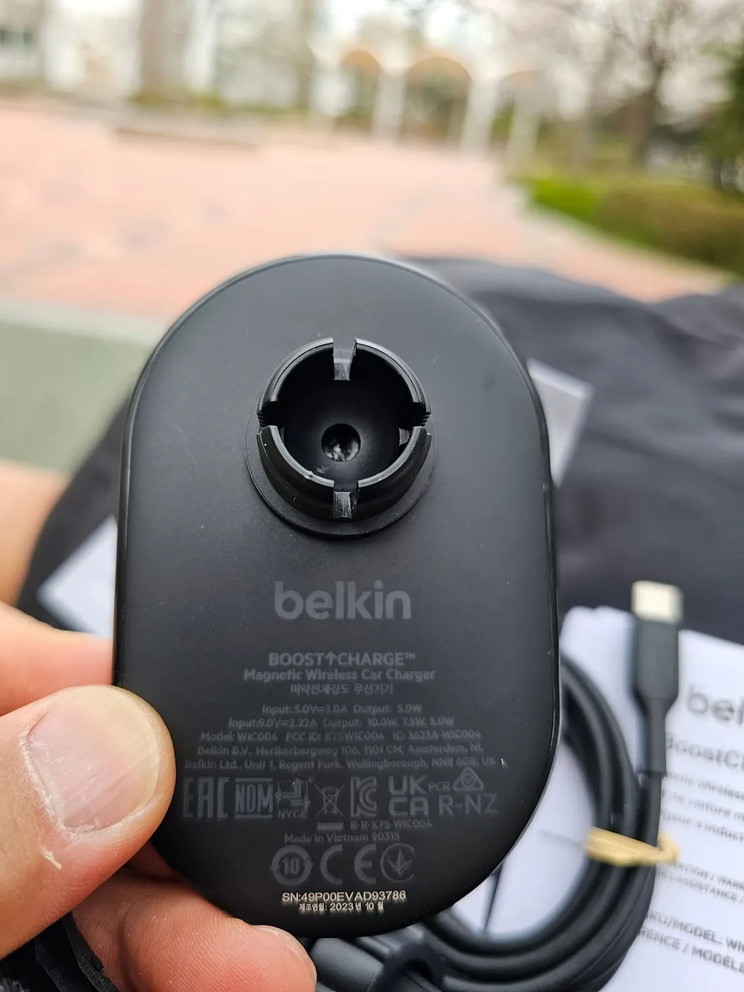 Moulded label on the back of the charger showing model WIC004, input and output ratings, and certification marks