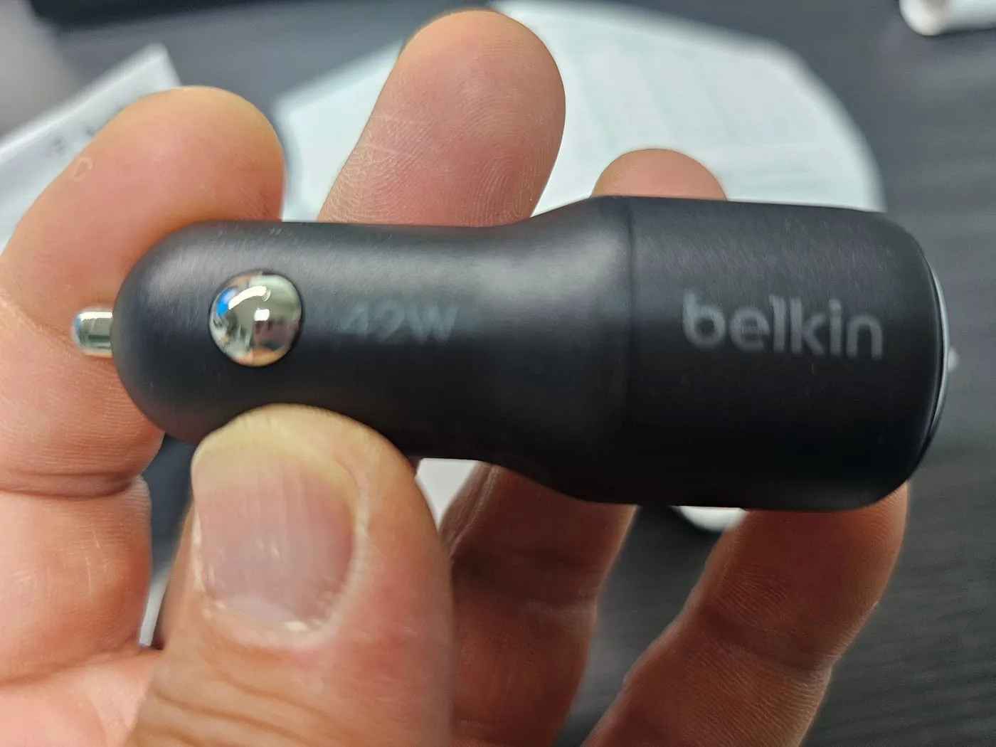 검은색 원통형 본체를 손에 든 모습. 옆면에 belkin 로고와 42W 각인이 있다