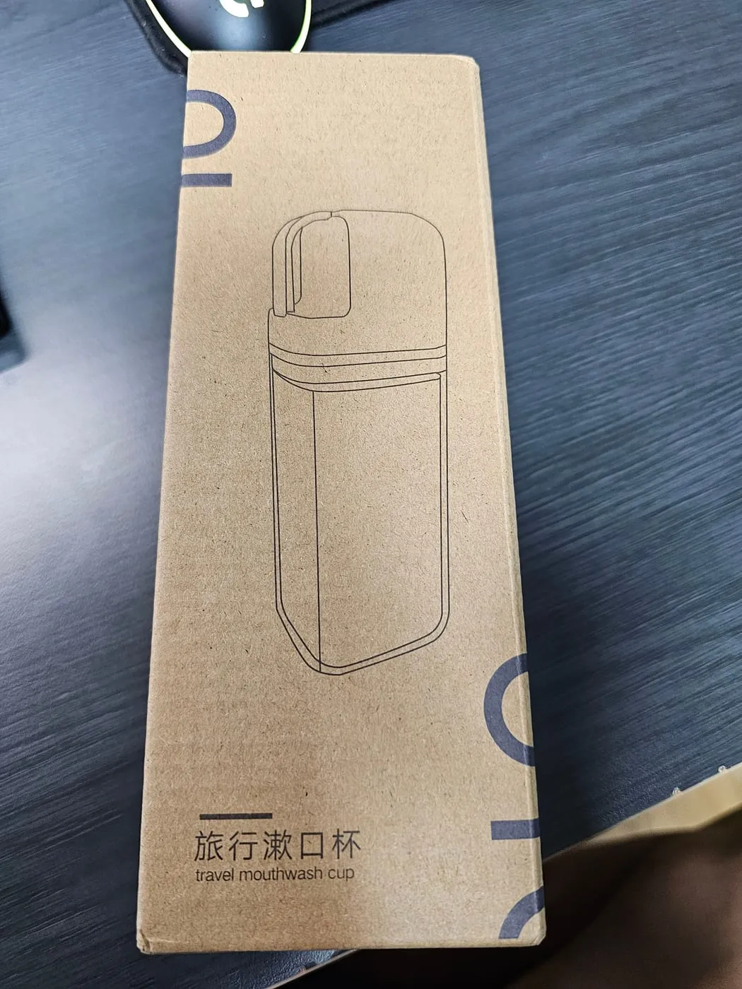 크라프트 종이 상자. 컵 외곽선 그림과 旅行漱口杯, travel mouthwash cup 표기가 있다