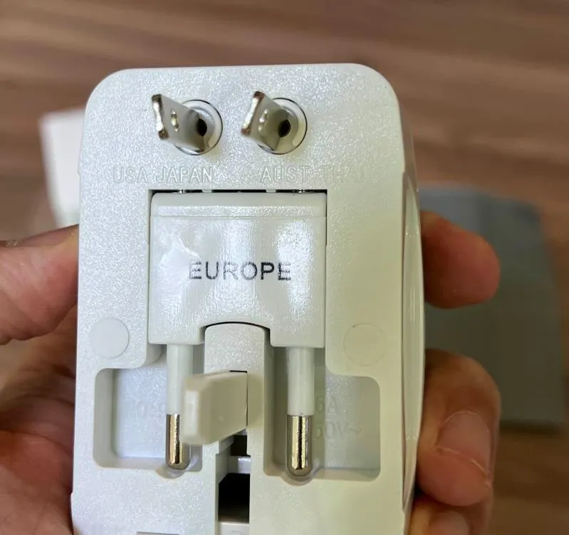 EUROPE 플러그를 뽑아낸 상태. 둥근 핀 두 개가 나와 있고 위쪽에 USA JAPAN, AUST 글자가 보인다