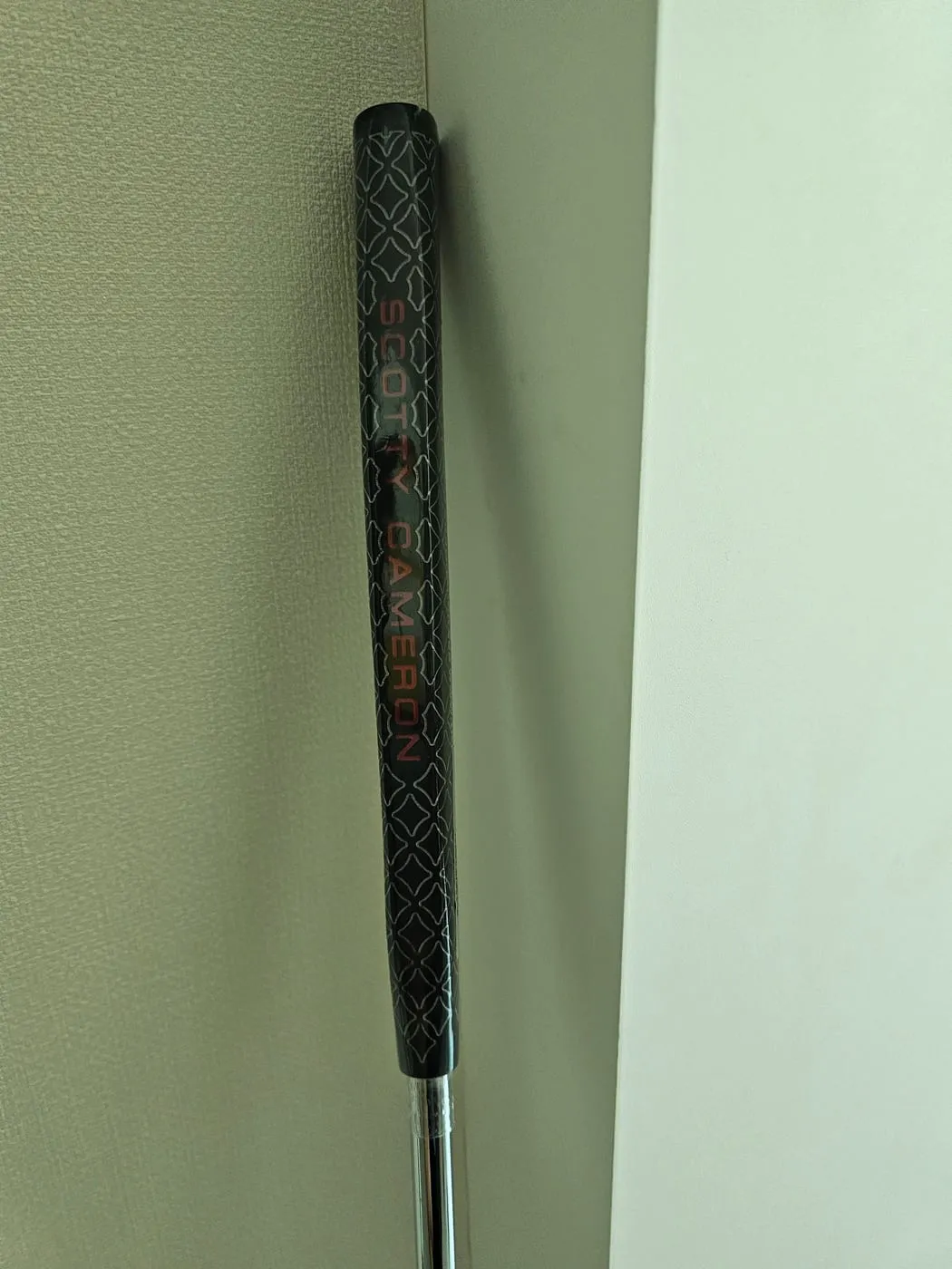 퍼터 그립 근접. 검정 바탕에 SCOTTY CAMERON 각인과 마름모 패턴