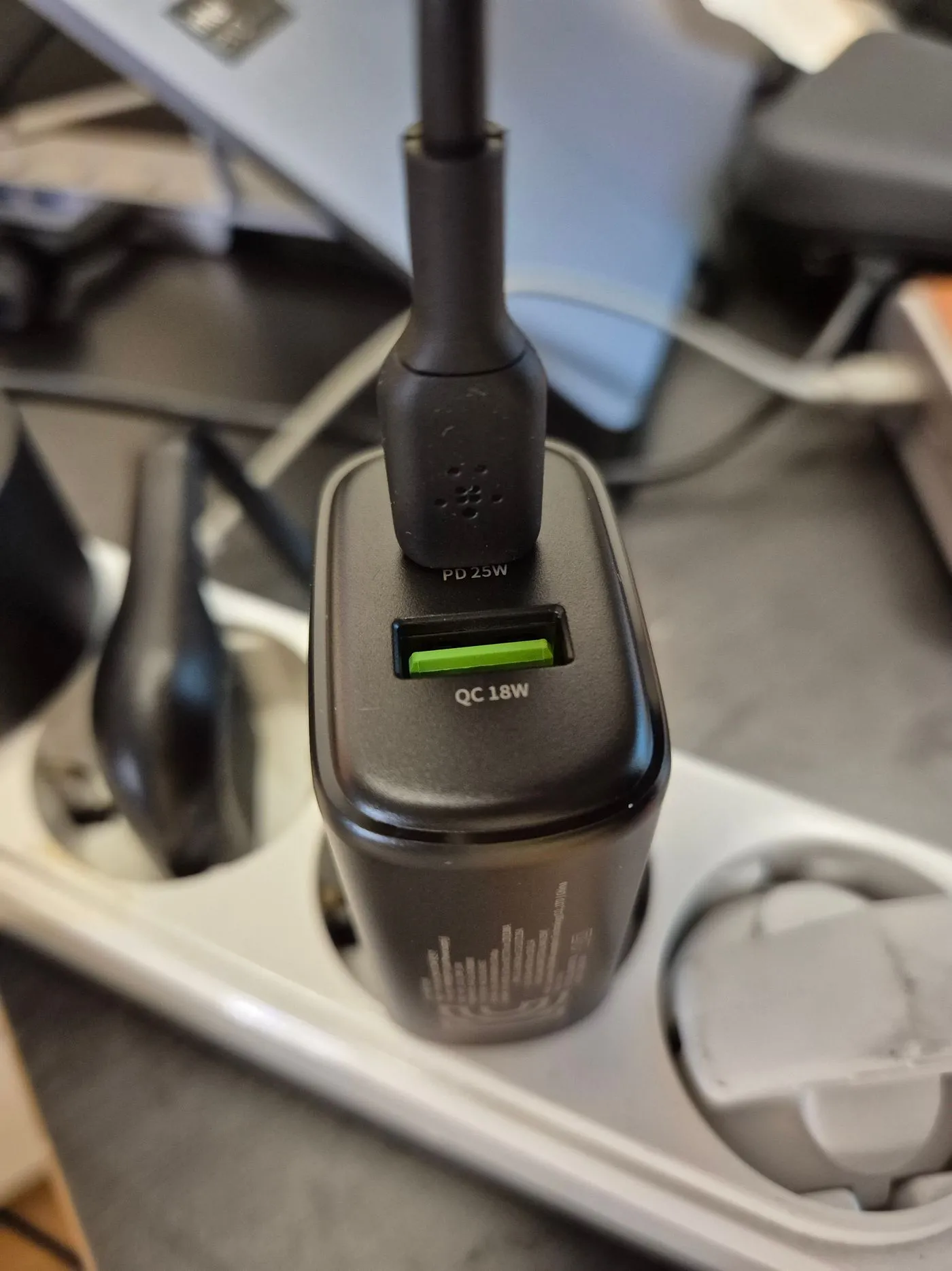 멀티탭에 꽂힌 충전기, USB-C 포트에 케이블이 연결돼 있고 아래에 QC 18W 포트