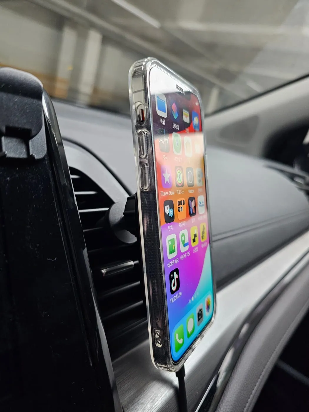 The charger mounted on a car air vent with a phone attached, seen from the driver’s seat