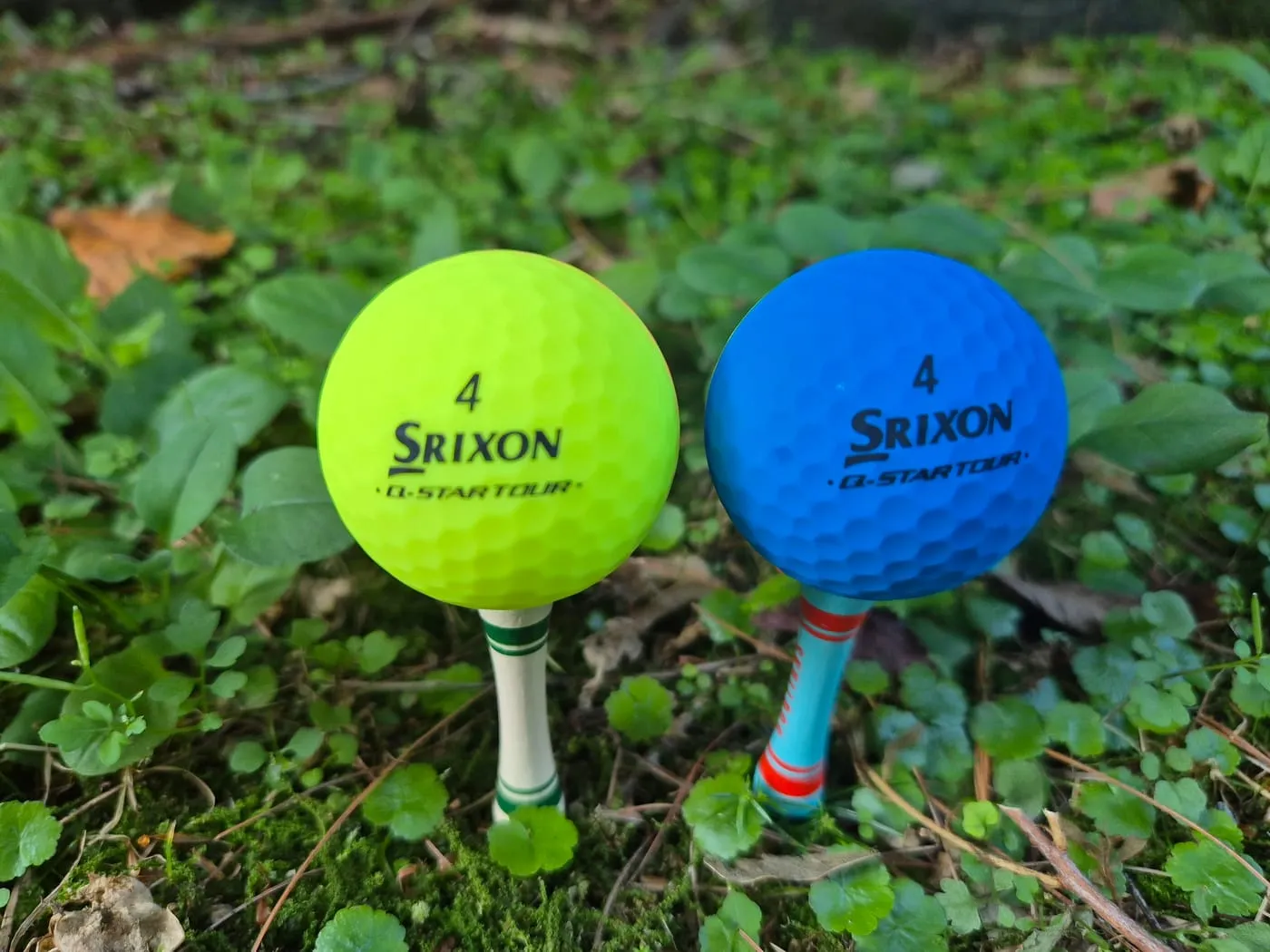 티 위에 올린 노란 공과 파란 공. SRIXON Q-STAR TOUR와 번호 4가 인쇄돼 있다