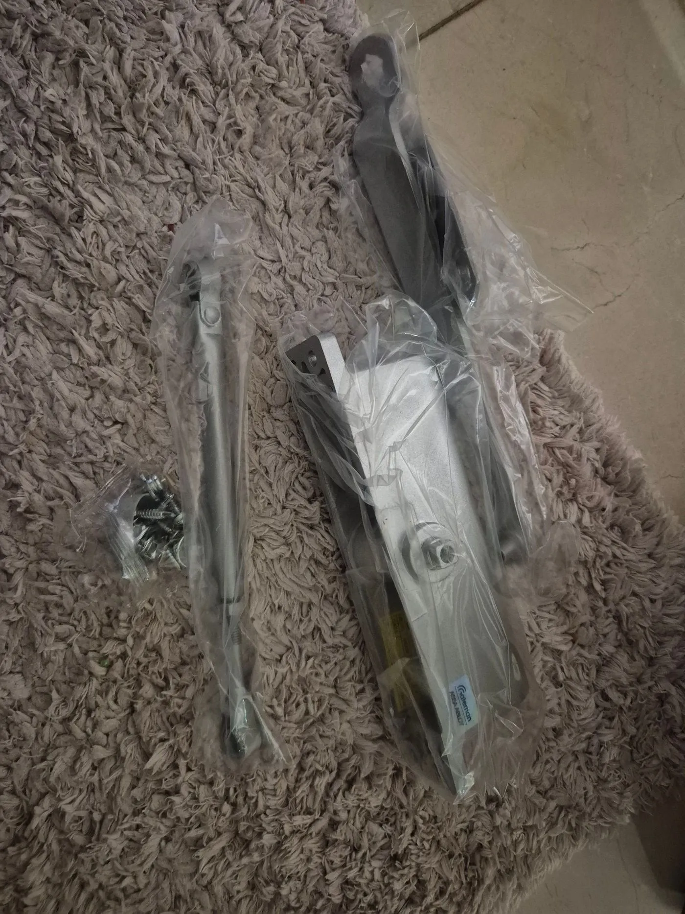 비닐 포장된 도어클로저 본체와 암, 브래킷