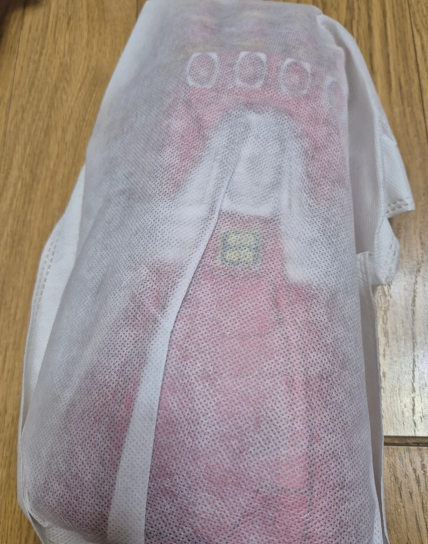 흰 부직포 주머니에 든 빨간 건틀렛