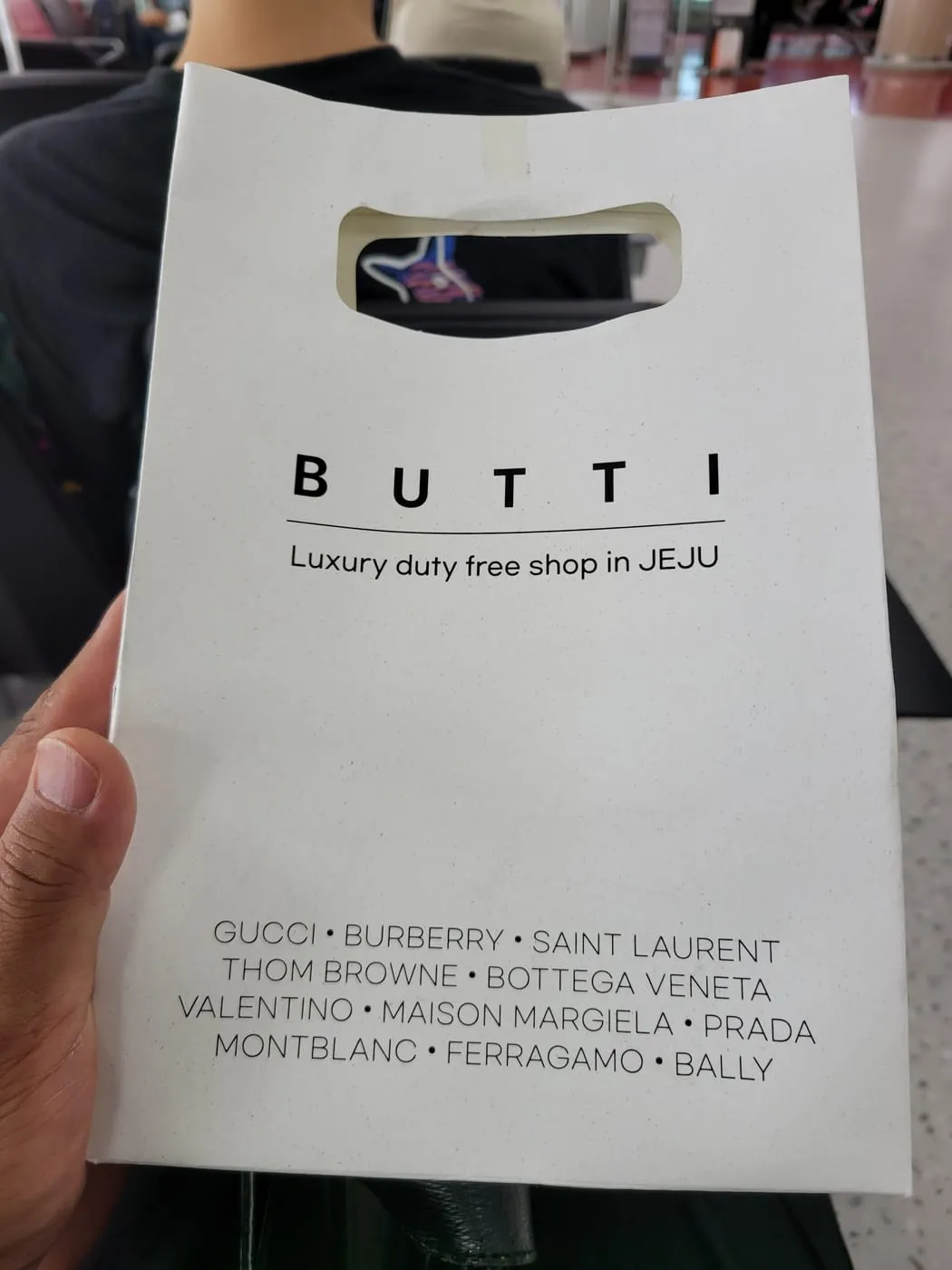 BUTTI 쇼핑백. Luxury duty free shop in JEJU 문구와 입점 브랜드 목록이 인쇄돼 있다