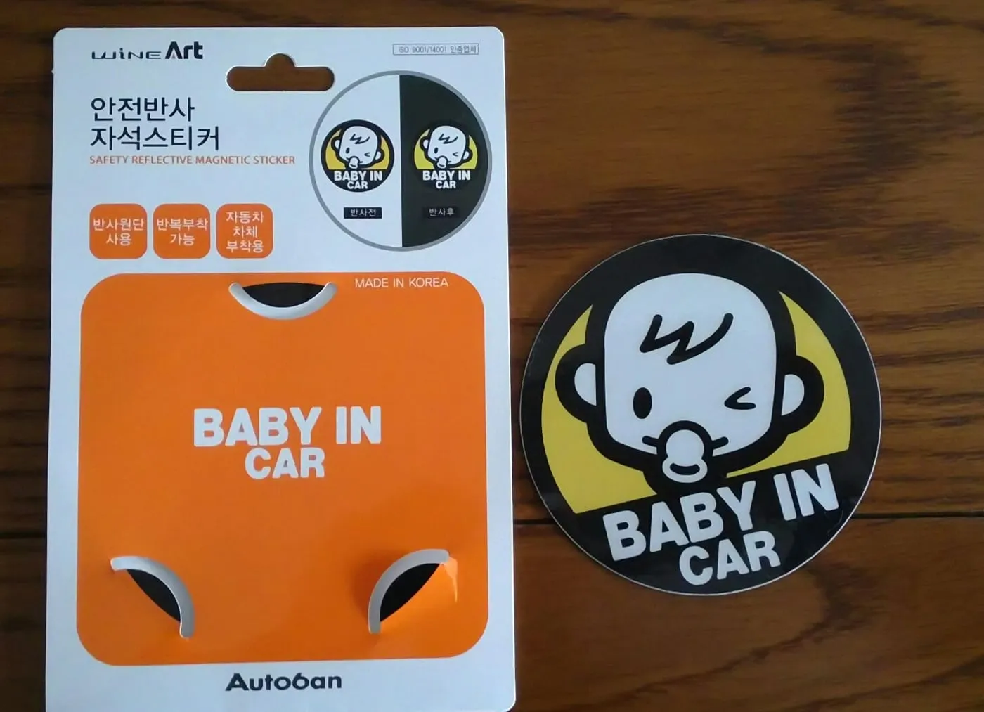 포장에서 꺼낸 원형 BABY IN CAR 자석스티커와 빈 포장
